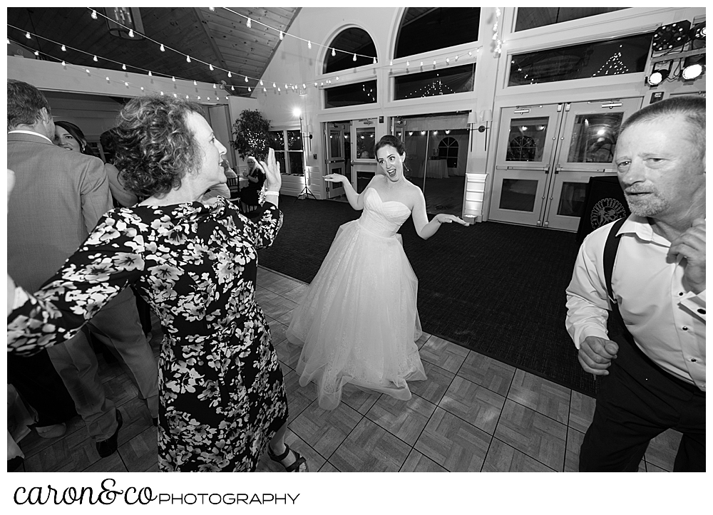 black and white photo of a bride dancing with her mother and father during a Spruce Point Inn Maine wedding reception