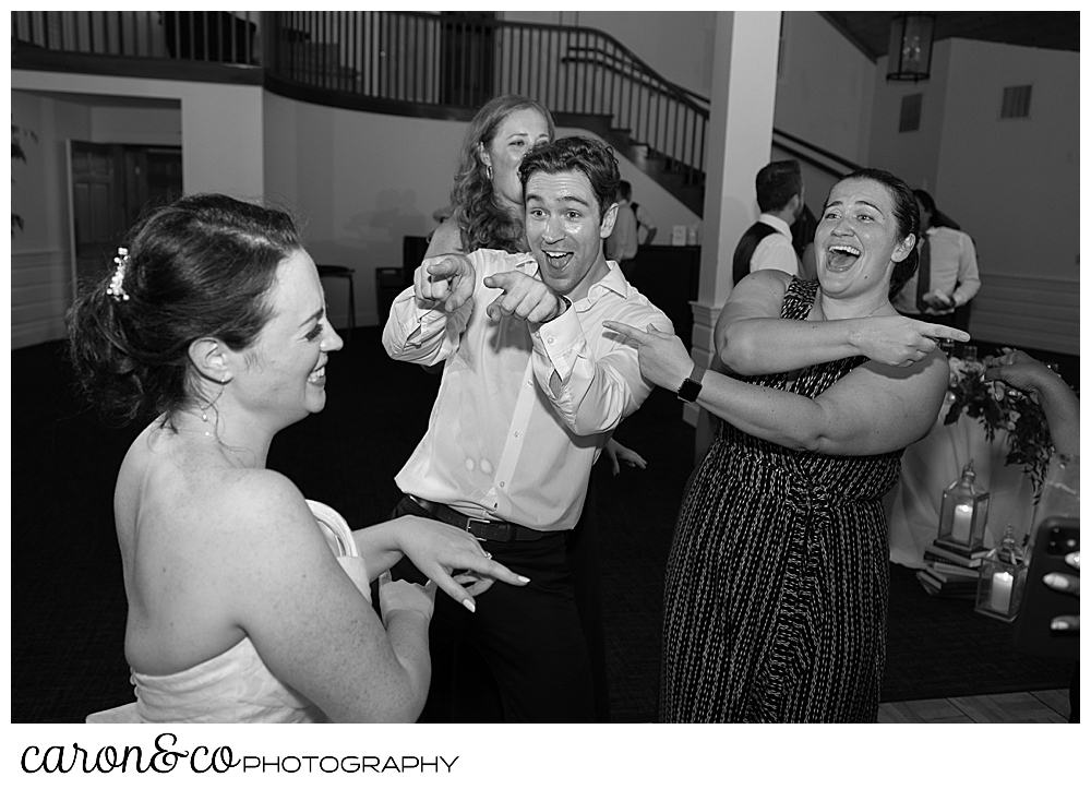 a black and white photo of a bride having fun on the dance floor with her wedding guests