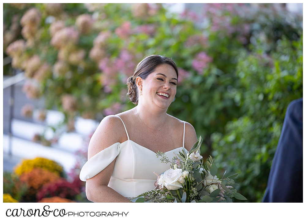 a bride smiles as her groom comes towards her during their wedding day first look