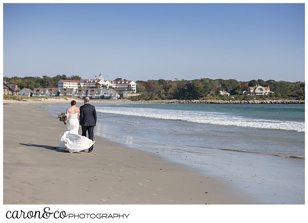 a bride and groom walk away on Gooch's Beach, Kennebunk, Maine