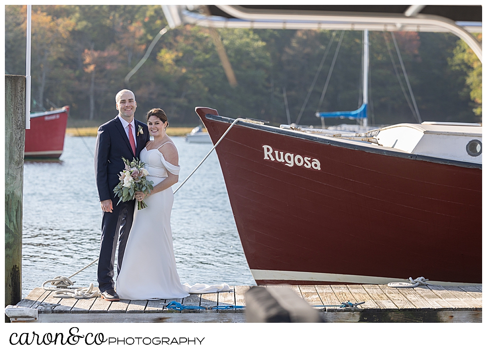a bride and groom stand together on the dock of the Nonantum Resort, Kennebunkport, Maine