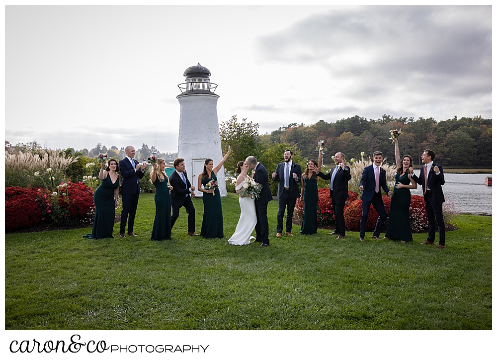 a bride and groom kiss, while their bridal party cheers on the lawn at The Nonantum Resort, Kennebunkport, Maine