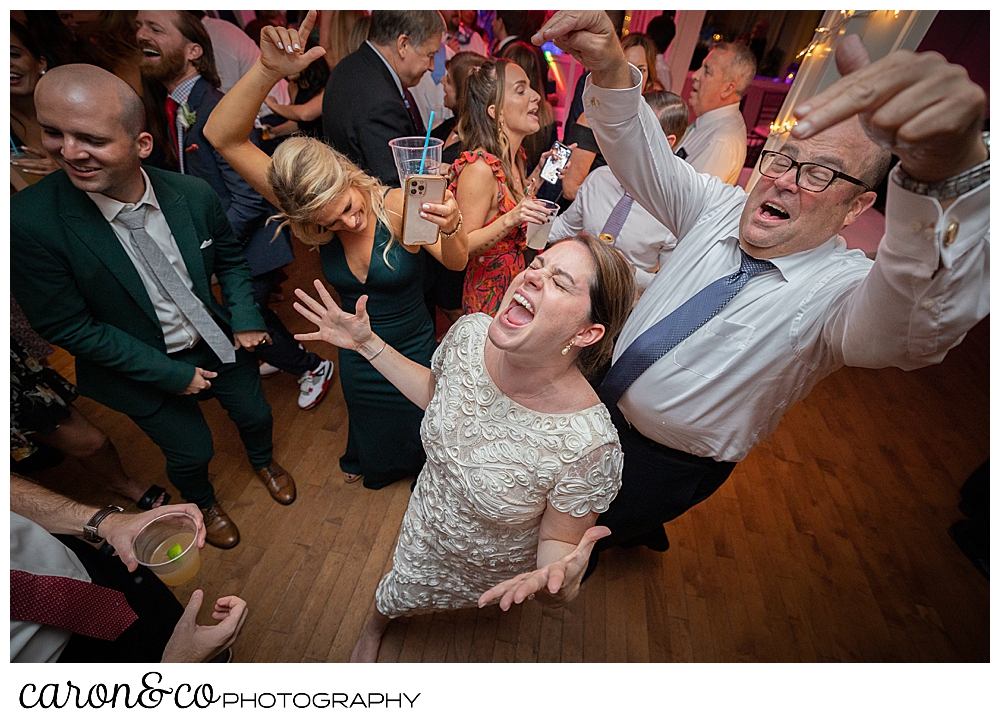 a bride sings and dances, her father behind her, at a Nonantum Resort Kennebunkport Maine wedding reception