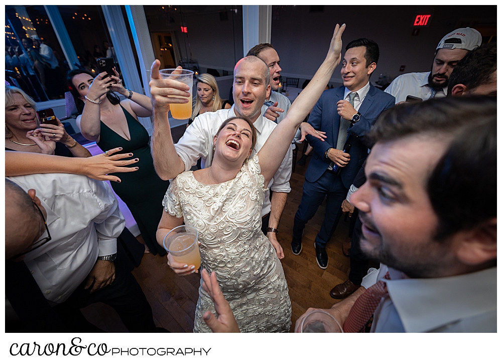 a bride and groom dance, the brides left arm is up in the air, the groom is behind her, at a Nonantum Resort Kennebunkport Maine wedding reception