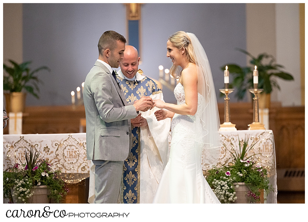 a bride and groom exchange rings during a wedding ceremony at St. Joseph's Church in Biddeford Maine
