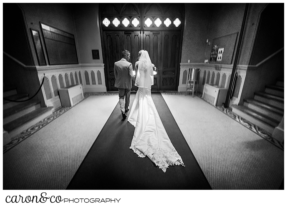 a black and white photo of a bride and groom at the end of their recessional, getting ready to leave St. Joseph's Church Biddeford Maine