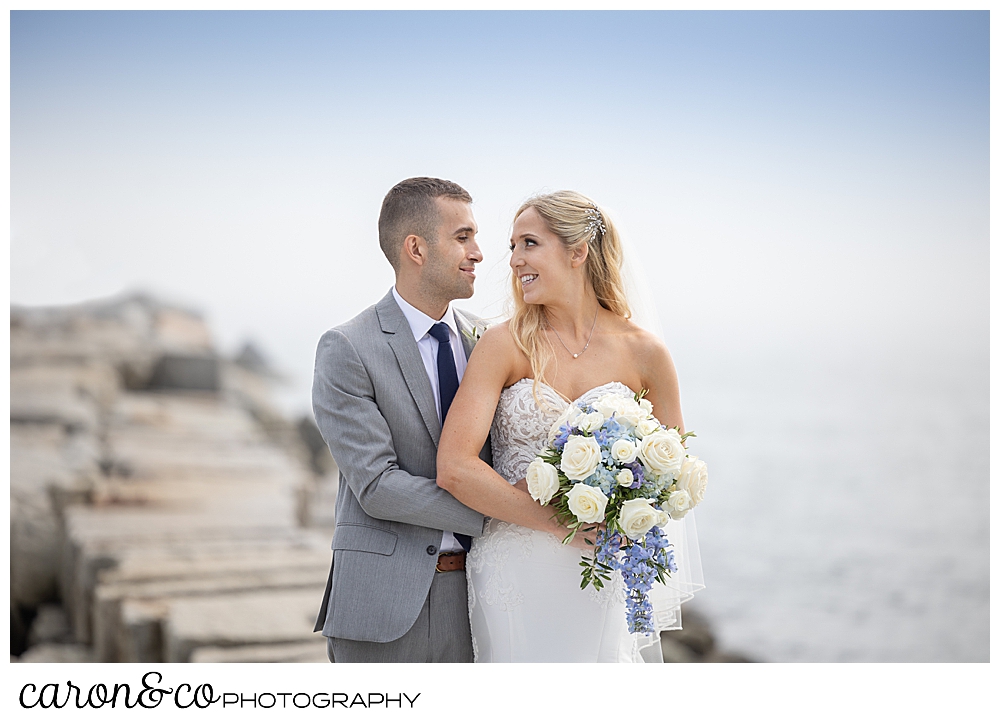 a bride and groom standing together, side by side, on the Breakwater at Colony Beach, Kennebunkport Maine