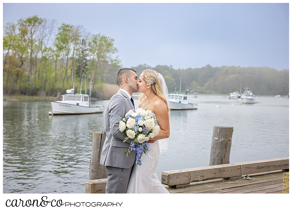a bride and groom kiss on a dock at a breakwater inn Kennebunkport wedding in Kennebunkport Maine