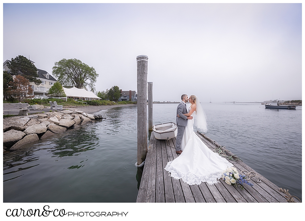 a bride and groom kissing in the fog on a dock in Kennebunkport, with the Breakwater Inn in the background, during a breakwater inn Kennebunkport wedding Kennebunkport Maine