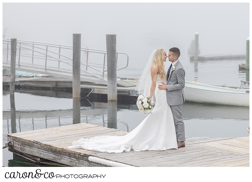 a bride and groom kiss on a dock, in the fog, at a breakwater inn Kennebunkport wedding, Kennebunkport, Maine