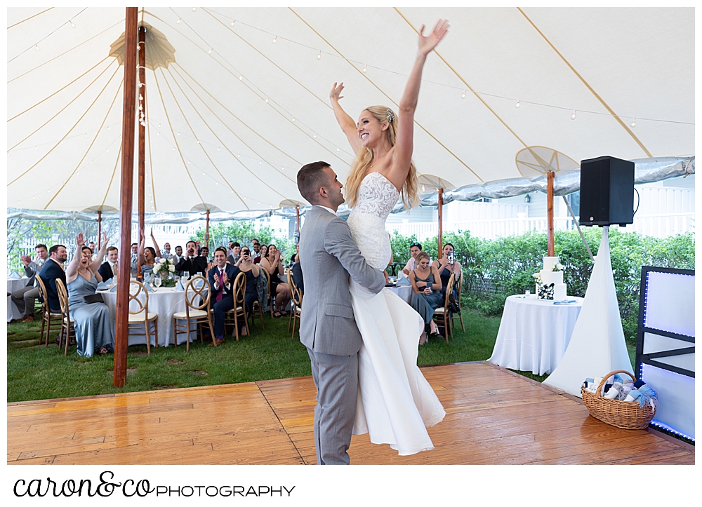 during their choreographed first dance, the groom lifts his bride at their tented breakwater inn Kennebunkport wedding reception