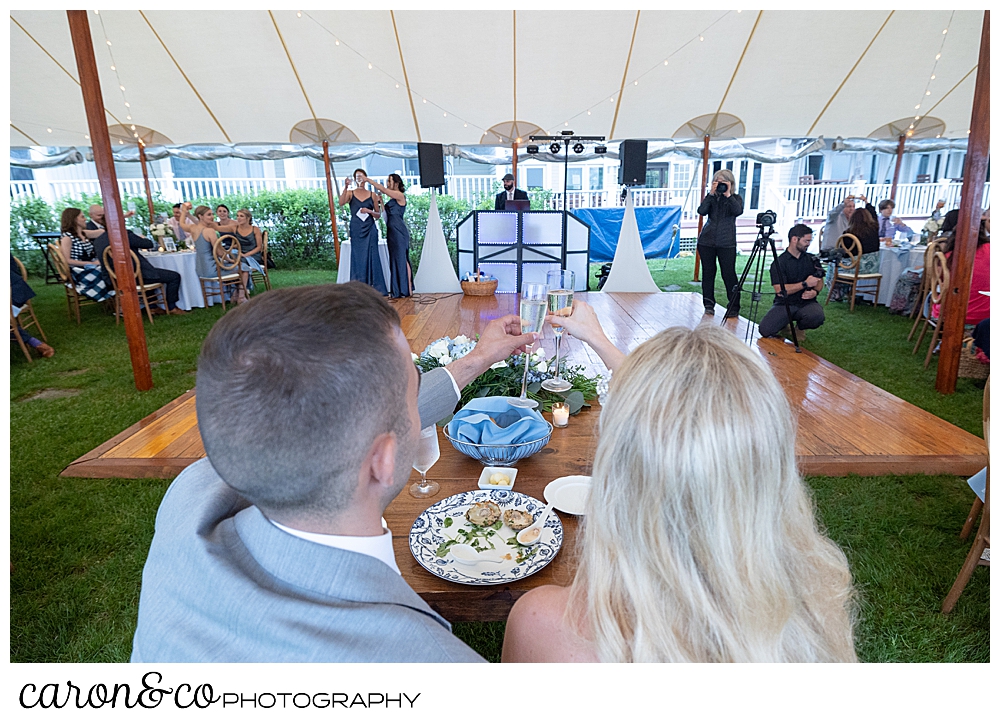 the bride and groom toast during the maids of honor toasts during a breakwater inn Kennebunkport wedding reception