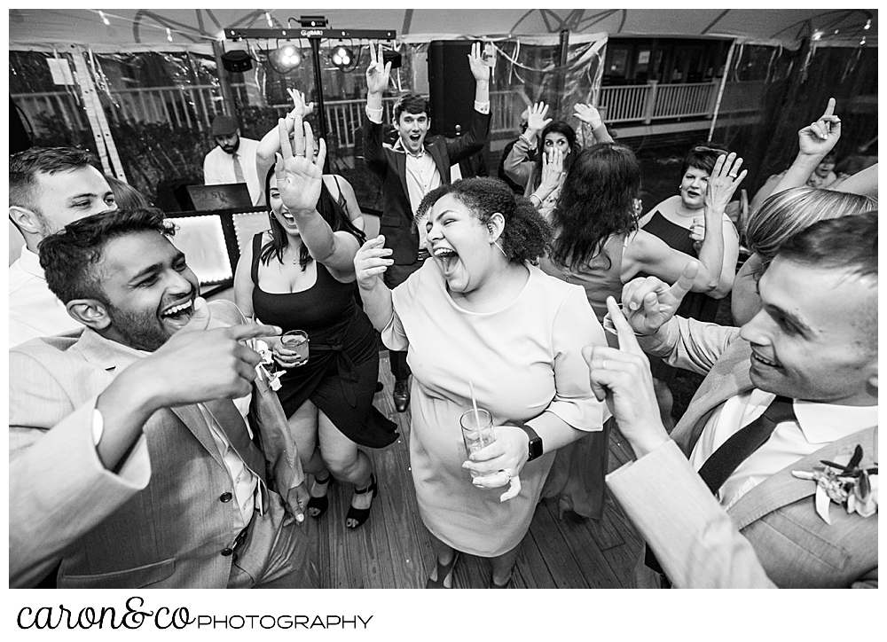 black and white photo of a woman dancing among wedding guests