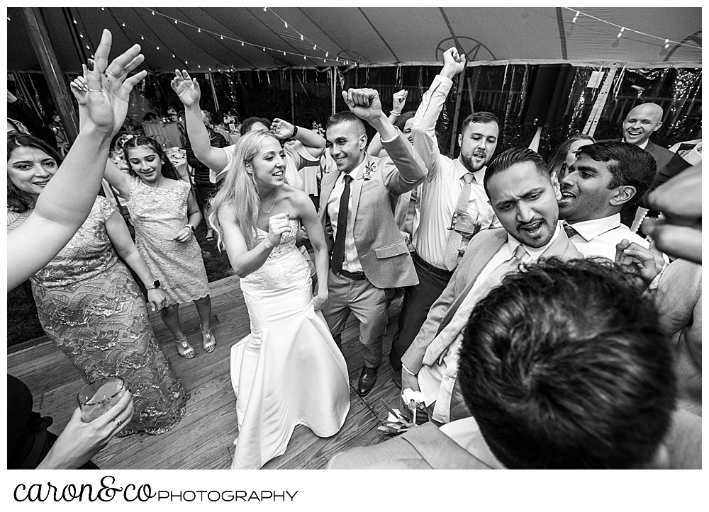 black and white photo of a bride and groom dancing with their wedding guests during a tented breakwater inn Kennebunkport wedding reception