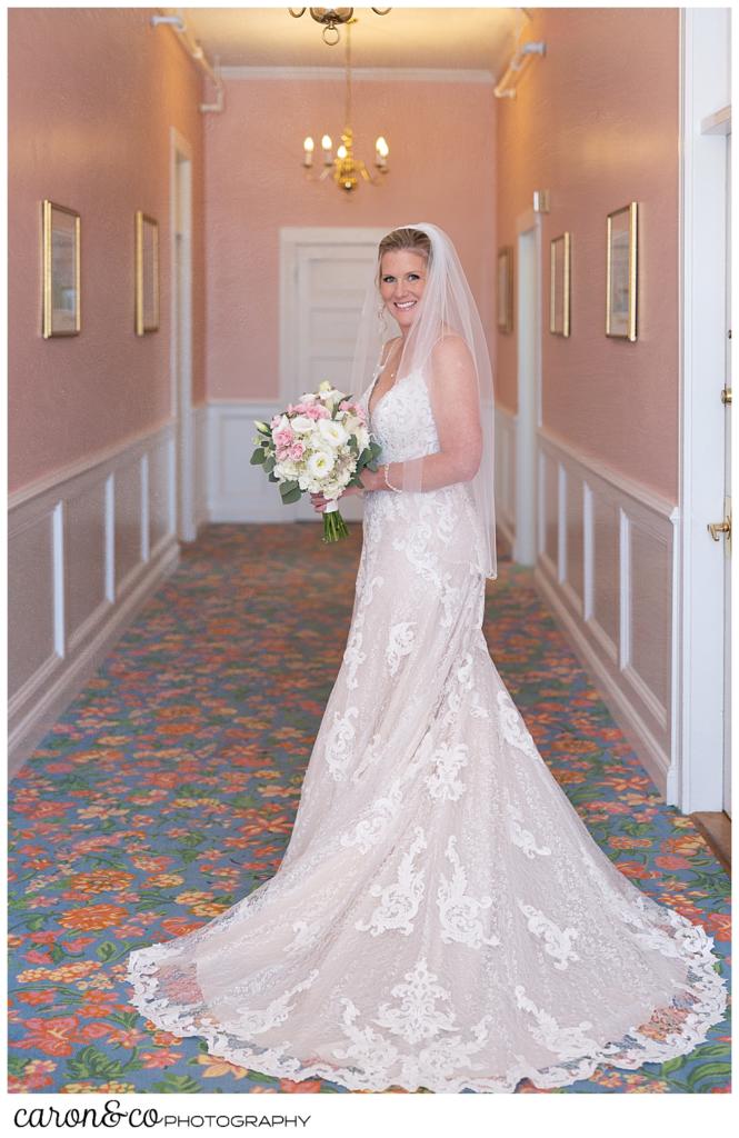 a bride poses in a pink hallway for a bridal portrait, at a Kennebunkport Maine colony hotel wedding