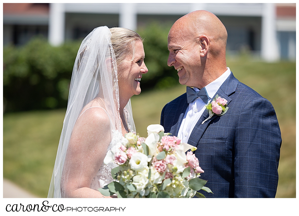 a bride and groom smile at each other during their wedding day first look at the colony hotel Kennebunkport Maine