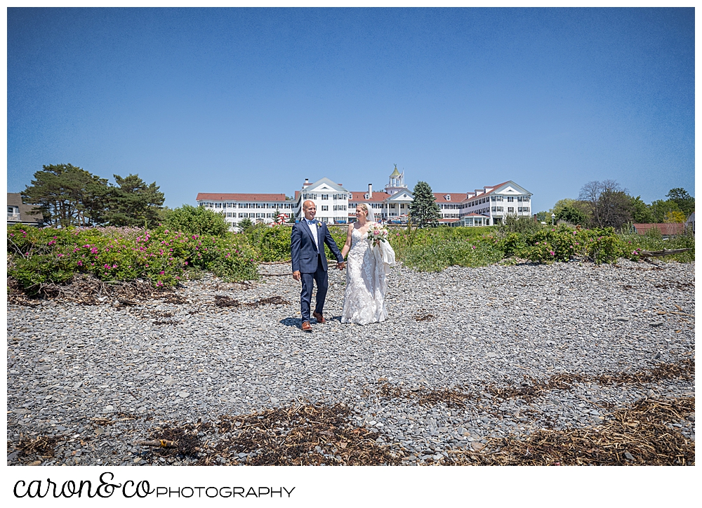 a bride and groom walk holding hands on colony beach Kennebunkport Maine