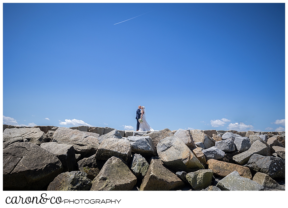a bride and groom kiss on the Kennebunkport Maine breakwater