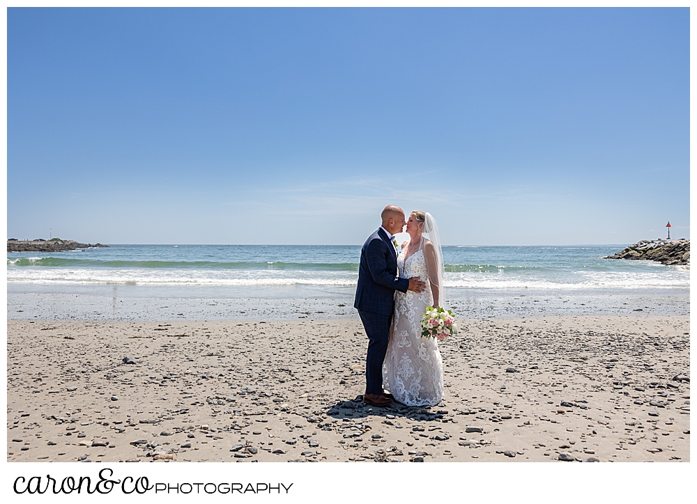 a bride and groom kiss on colony beach Kennebunkport maine