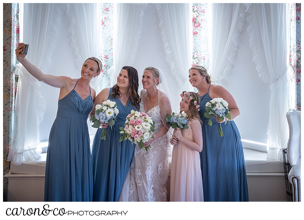 a bridesmaid takes a selfie with a bride and bridesmaids in a room at the colony hotel, Kennebunkport maine