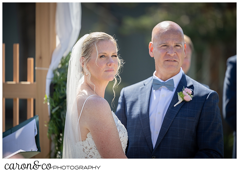 a bride and groom look pensive during their Kennebunkport Maine colony hotel wedding ceremony