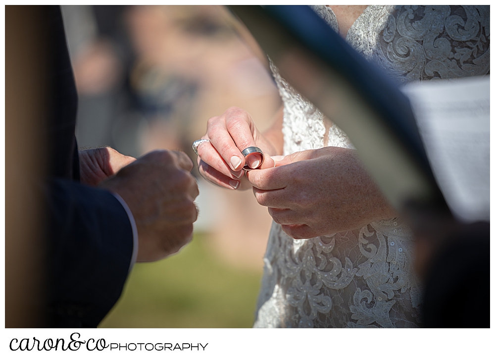 a bride holds the groom's ring in her hand during the ring ceremony at a Kennebunkport Maine colony hotel wedding