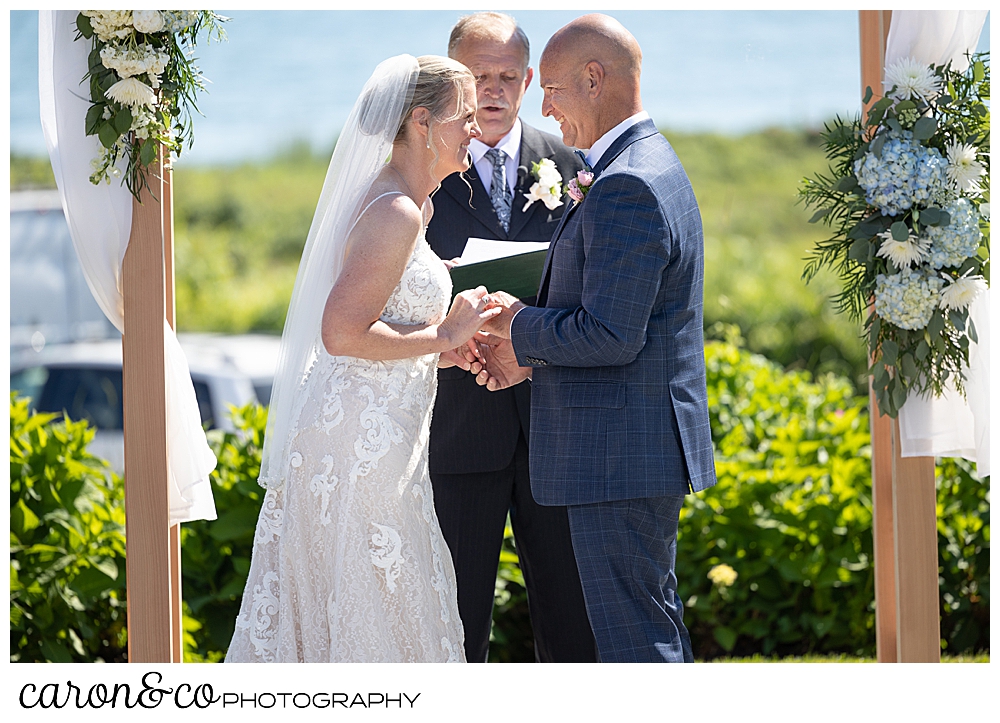 a bride and groom during the wedding ring ceremony at their Kennebunkport Maine colony hotel wedding