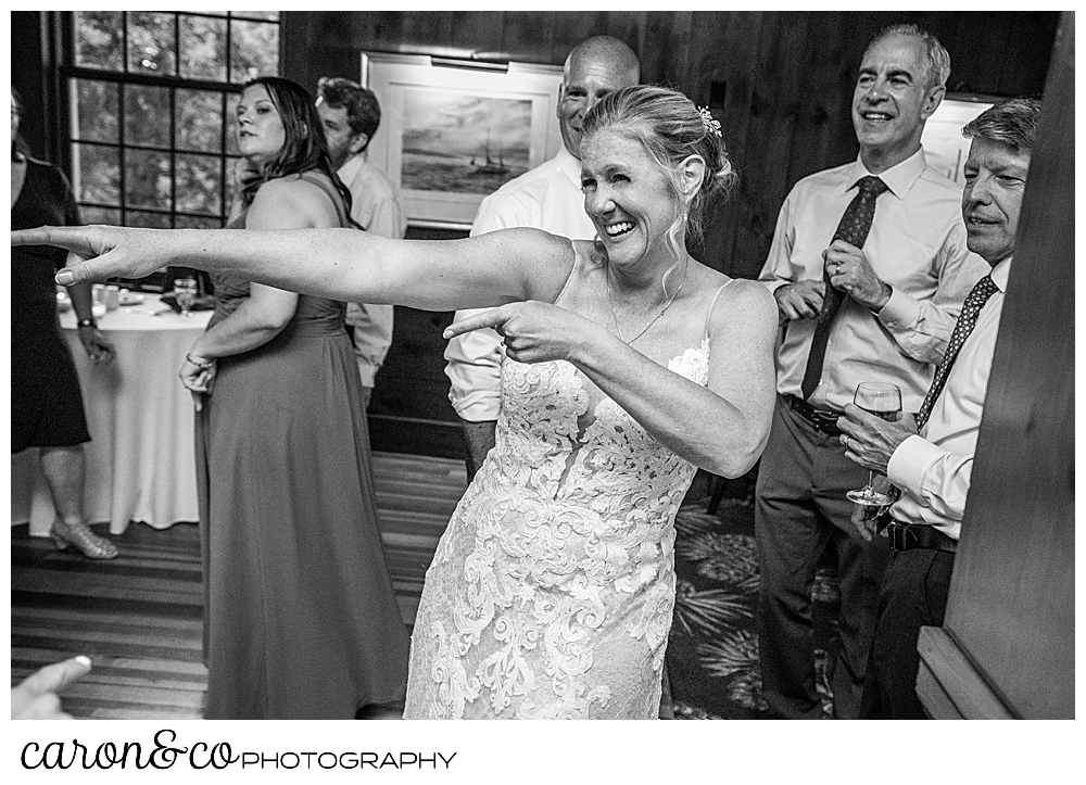 a black and white photo of a bride dancing and pointing on the dance floor at a Kennebunkport Maine colony hotel wedding reception