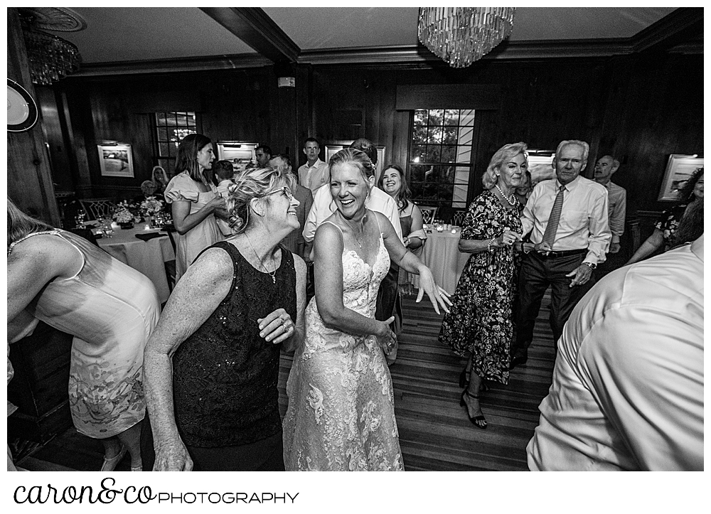 black and white photo of a bride enjoying herself on the dance floor with family and friends at a Kennebunkport Maine colony hotel wedding reception