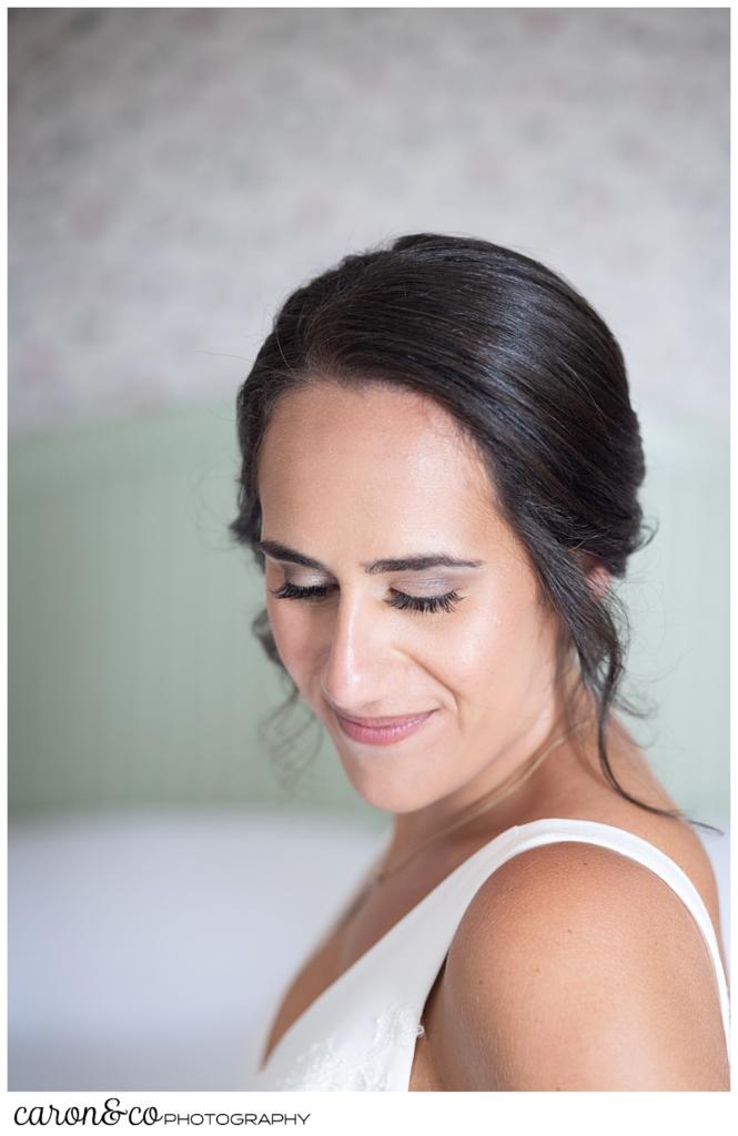 a bride looks to the side, a smile on her face, as she gets ready for her wedding day