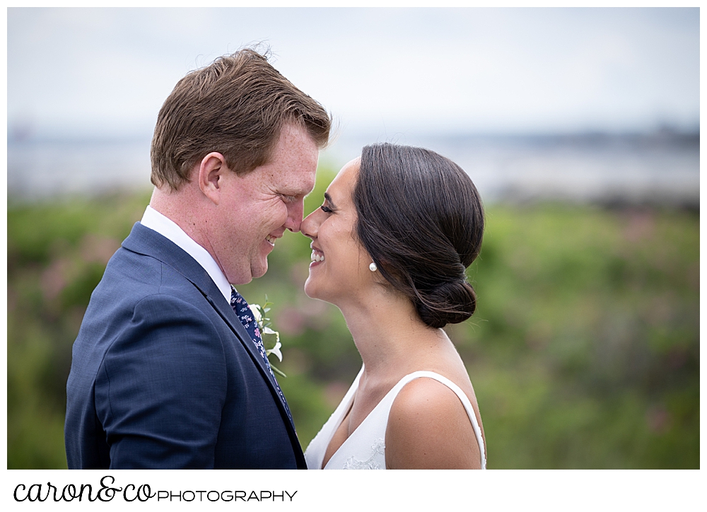a bride and groom are facing one another, smiling, with their noses touching, during their Kennebunkport Maine wedding at the colony hotel