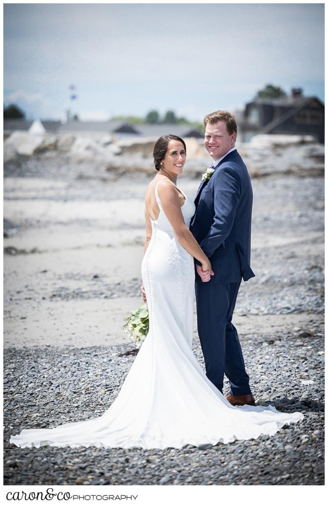 a bride and groom walking on Colony Breach, turn to look back at the camera