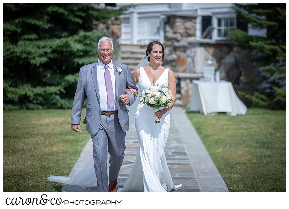 a bride and her father walk down the outdoor aisle at a Kennebunkport Maine wedding at the colony hotel