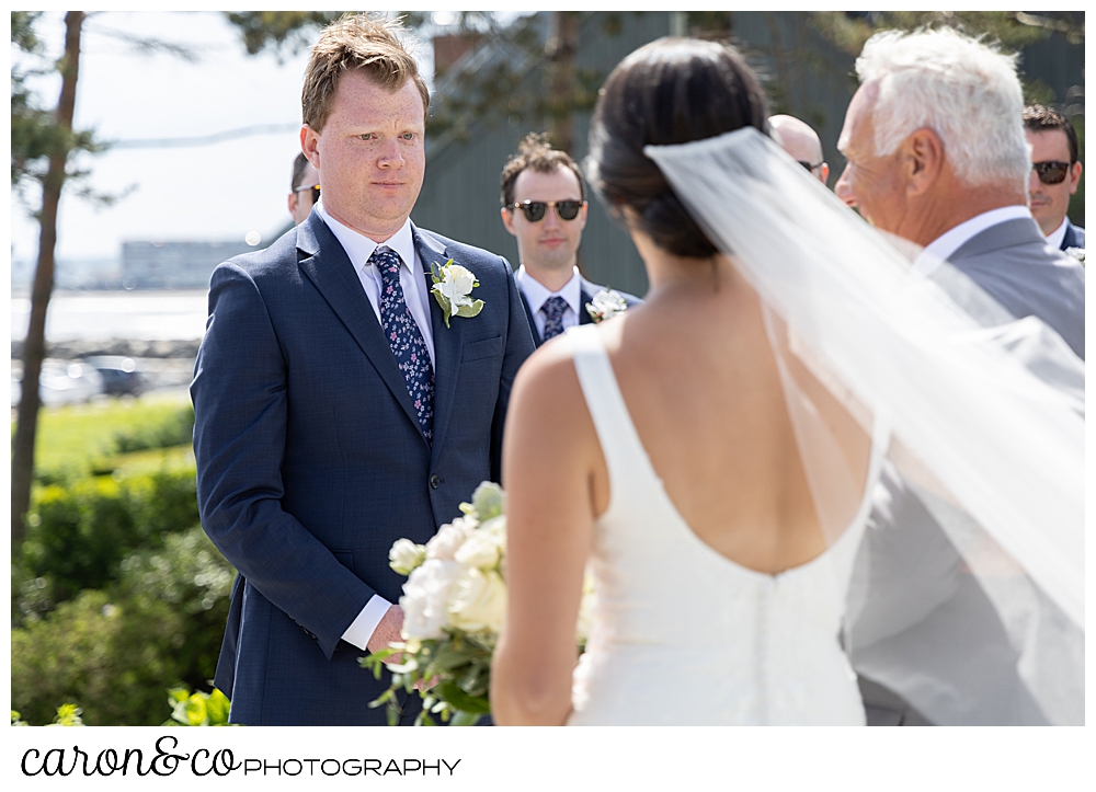 a groom stands before his bride at a Kennebunkport Maine wedding at the Colony Hotel