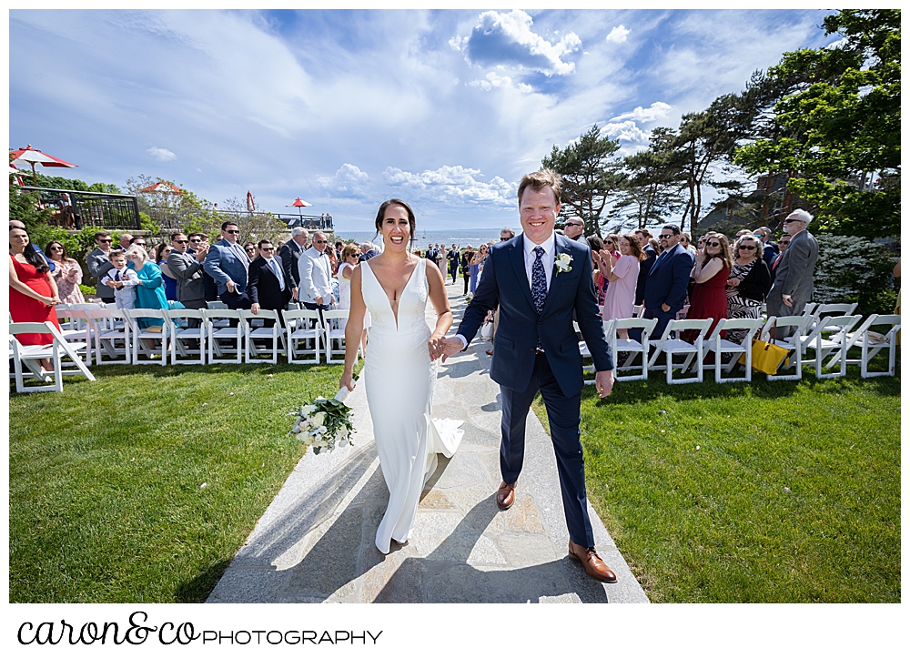 a bride and groom are all smiles after their wedding ceremony recessional at their Kennebunkport Maine wedding at the colony hotel