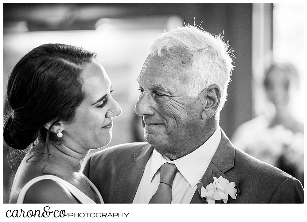 a father smiles at his daughter, the bride, during a father daughter dance