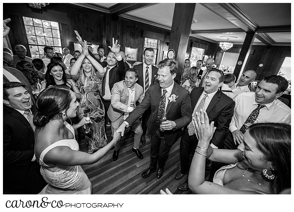 the bride and groom dance amid their friends and families on the dance floor at a Kennebunkport Maine wedding at the colony hotel