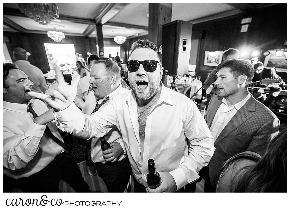 black and white wedding reception photo of a man in sunglasses, dancing