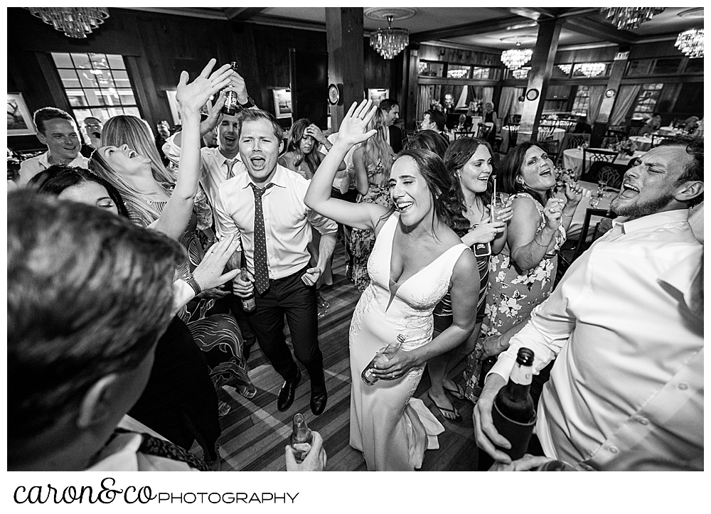 a black and white photo of the bride and groom on the dance floor with their guests