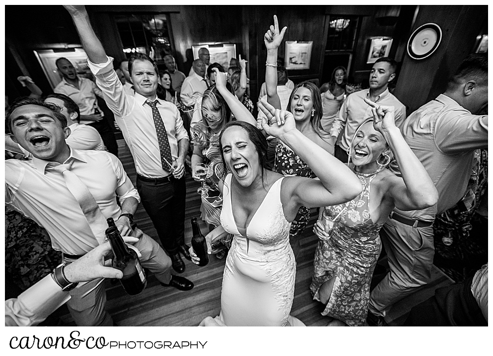 black and white photo of a bride rocking out on her wedding day, dancing to the Boston Band Legends of Summer