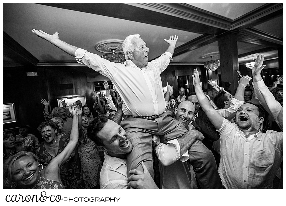 the father of the bride is raised on the dance floor during his daughter's Kennebunkport Maine wedding reception at the colony hotel
