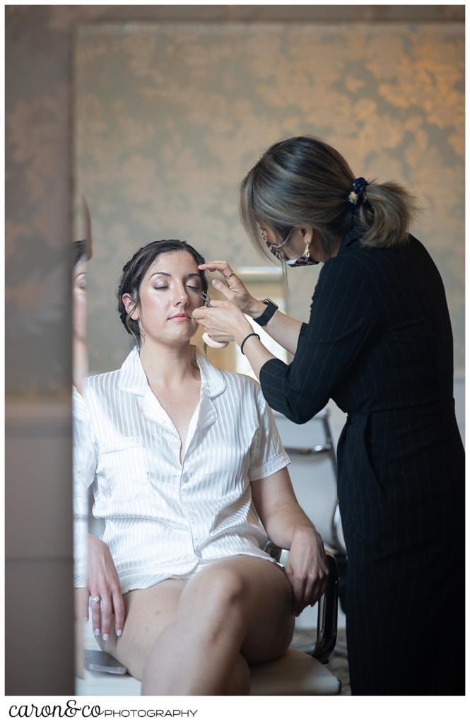 a bride gets a touch up just before she gets into her wedding dress