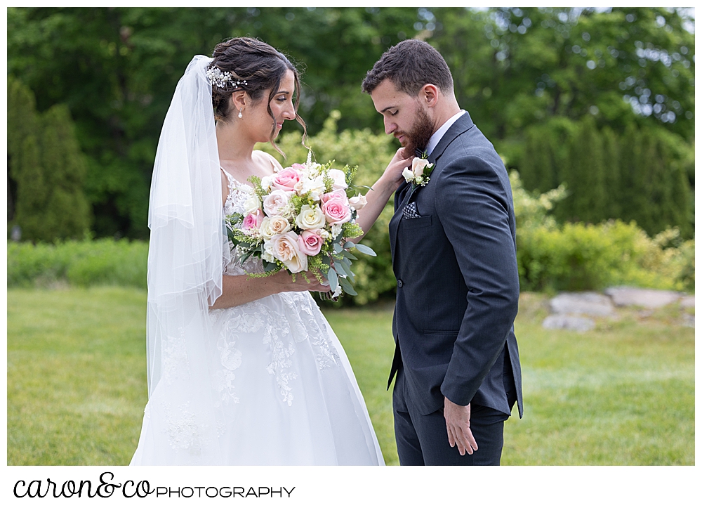 a groom looks at his bride's dress during their wedding day first look