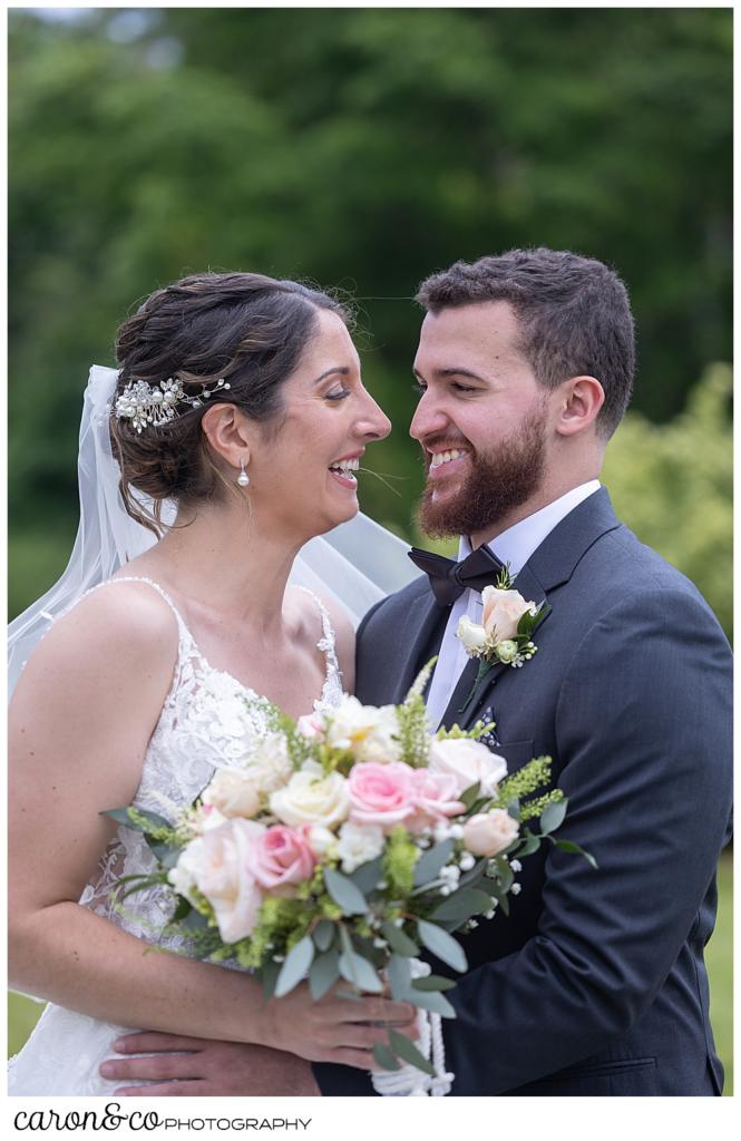 a bride and groom, standing face to face, smile at each other during their first look at a spring wedding at the colony hotel Kennebunkport Maine