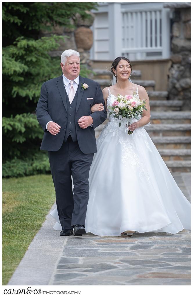 a bride and her father are walking down the aisle at a spring wedding at the colony hotel Kennebunkport Maine