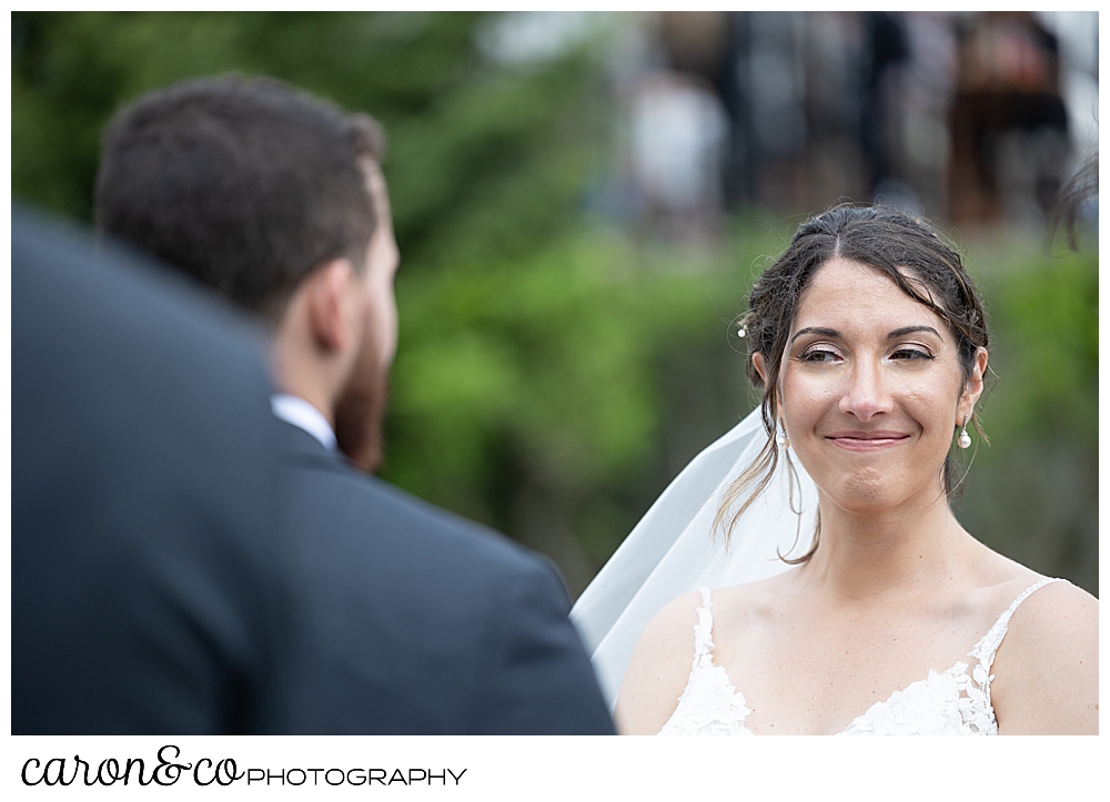 a bride smiles at her groom during an outdoor wedding ceremony at a spring wedding at the colony hotel