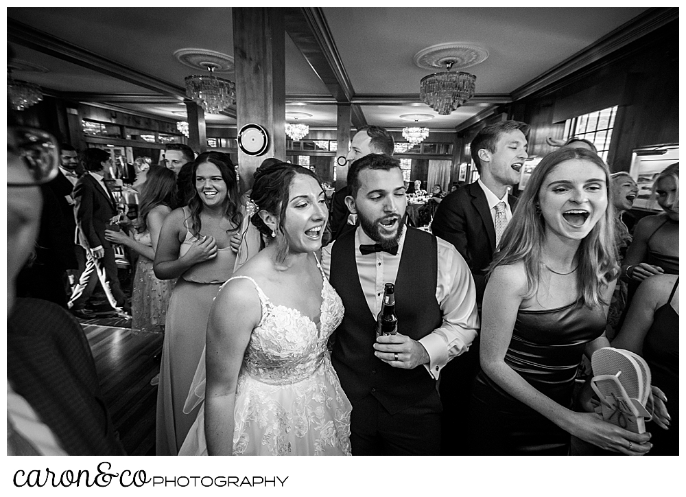 a black and white photo of the bride and groom singing during their spring wedding at the colony hotel reception
