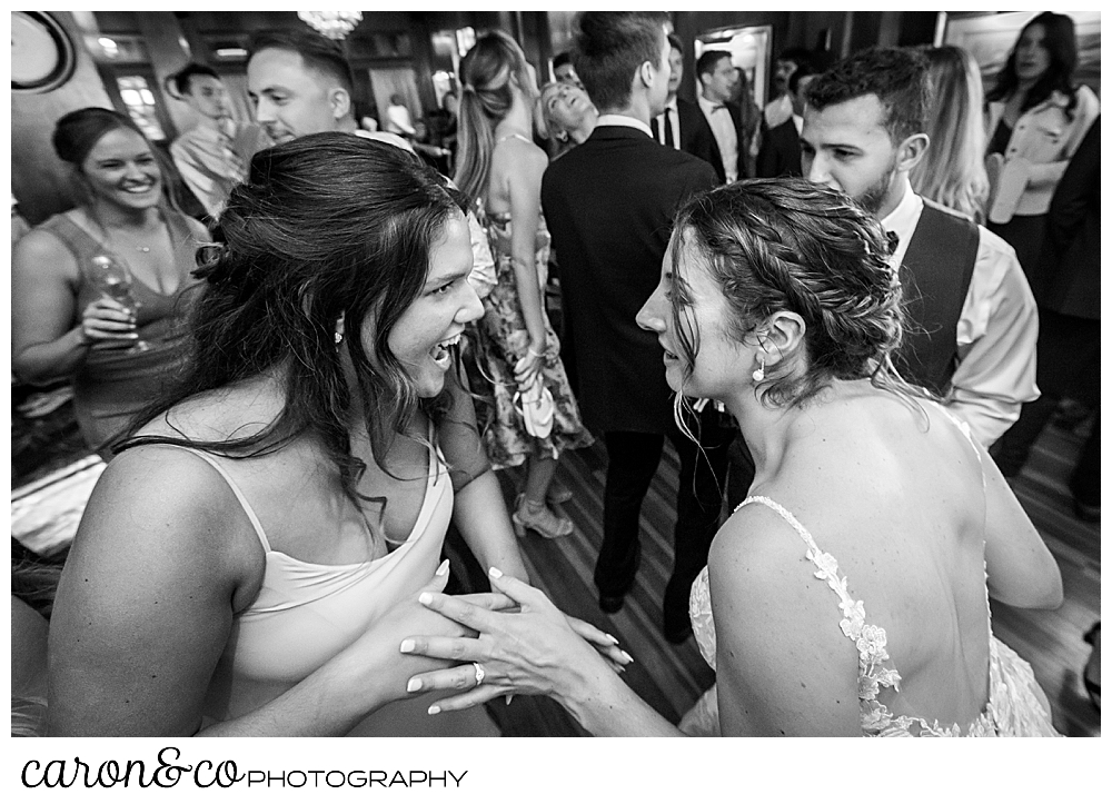 the bride dances with her bridesmaid during a spring wedding at the colony hotel