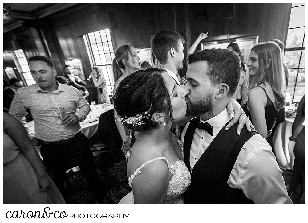 a black and white photo of a bride and groom kissing during their spring wedding at the colony hotel