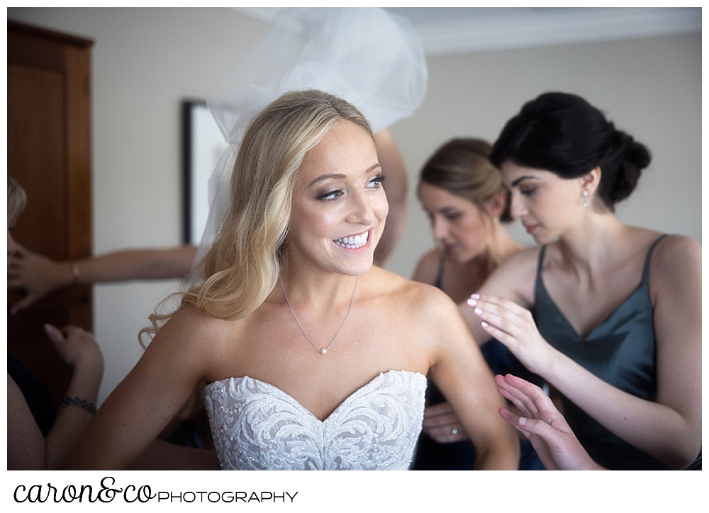 bride being helped getting into her gown on wedding day